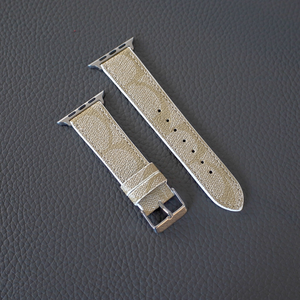 Light beige Apple Watch band on a dark textured background