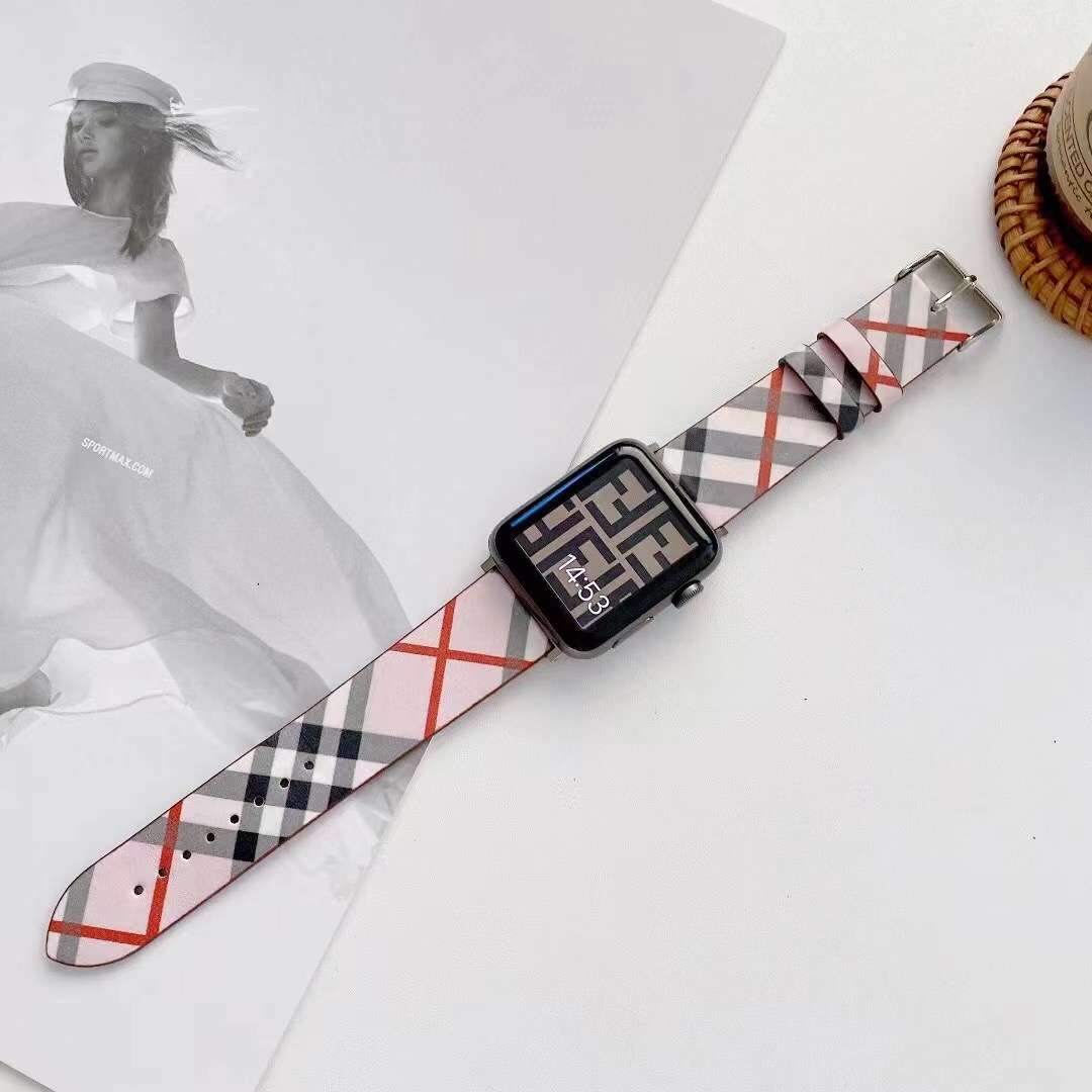 Plaid Apple Watch band attached to a black watch on a white surface