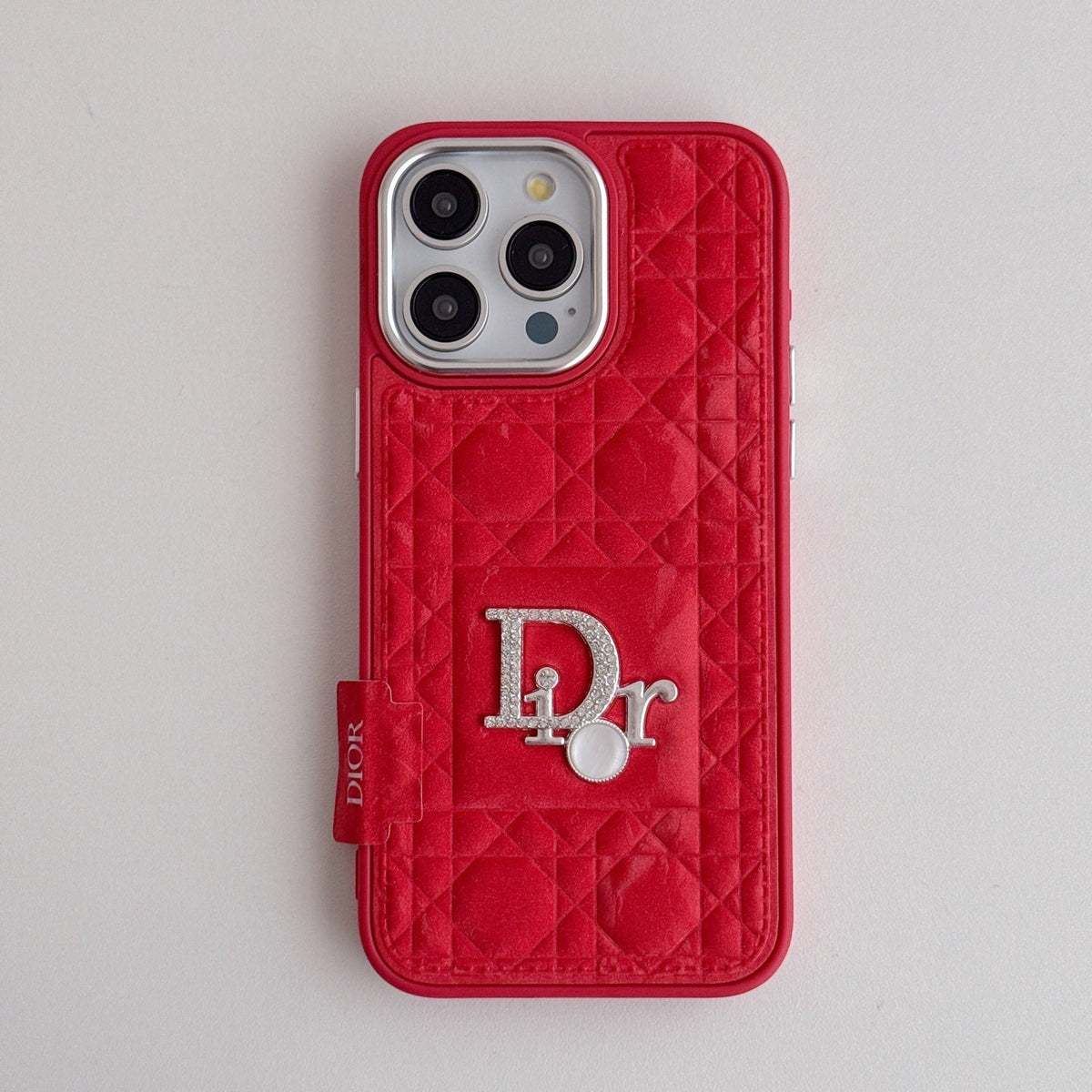 Red quilted iPhone case with a back grip tab and silver-tone emblem