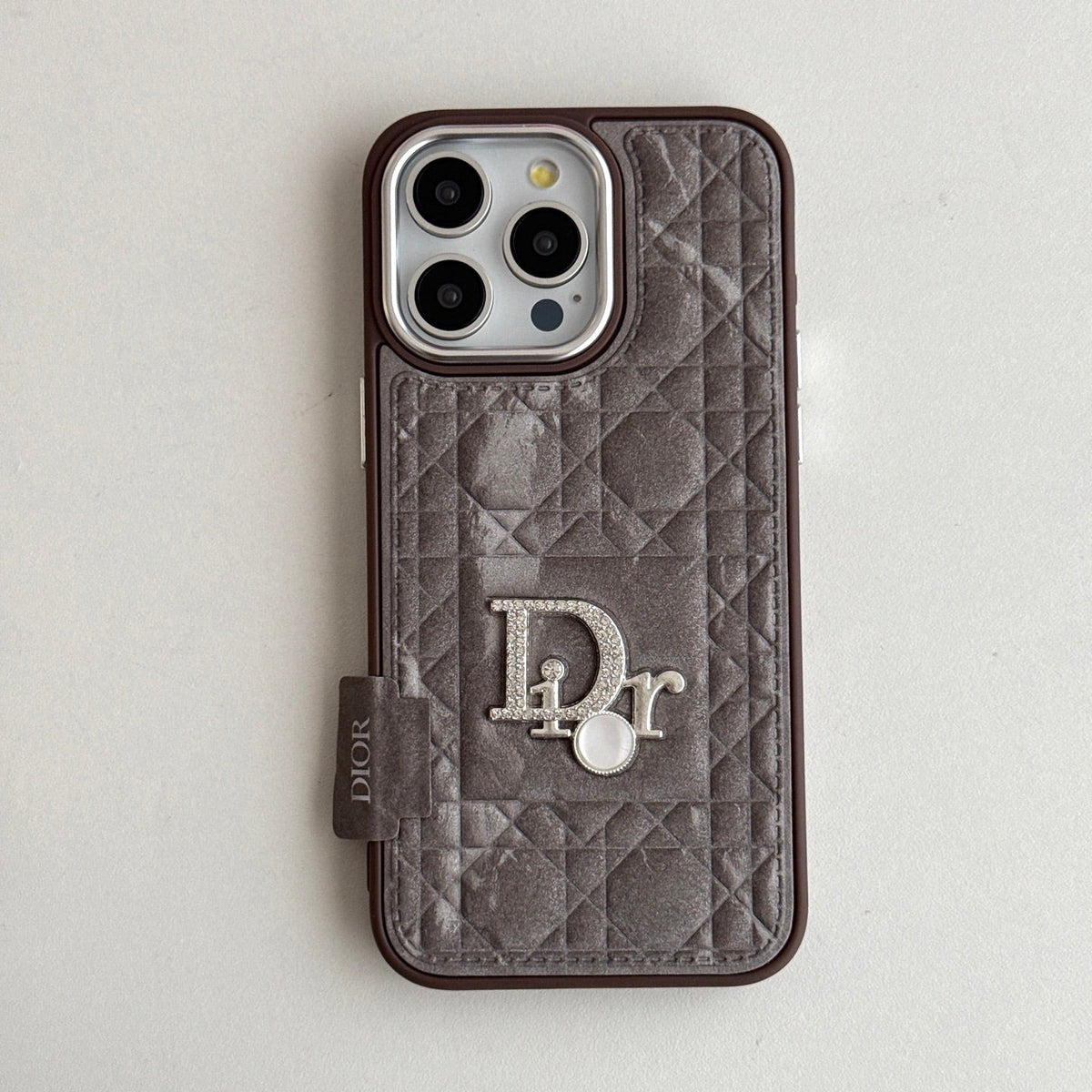 Taupe quilted iPhone case with a back grip tab and silver-tone emblem