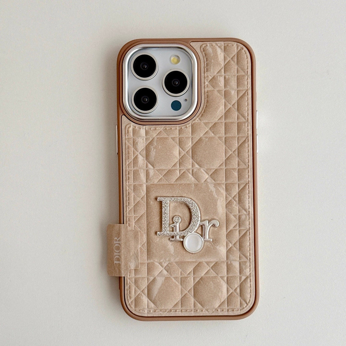 Champagne quilted iPhone case with a back grip tab and silver-tone emblem