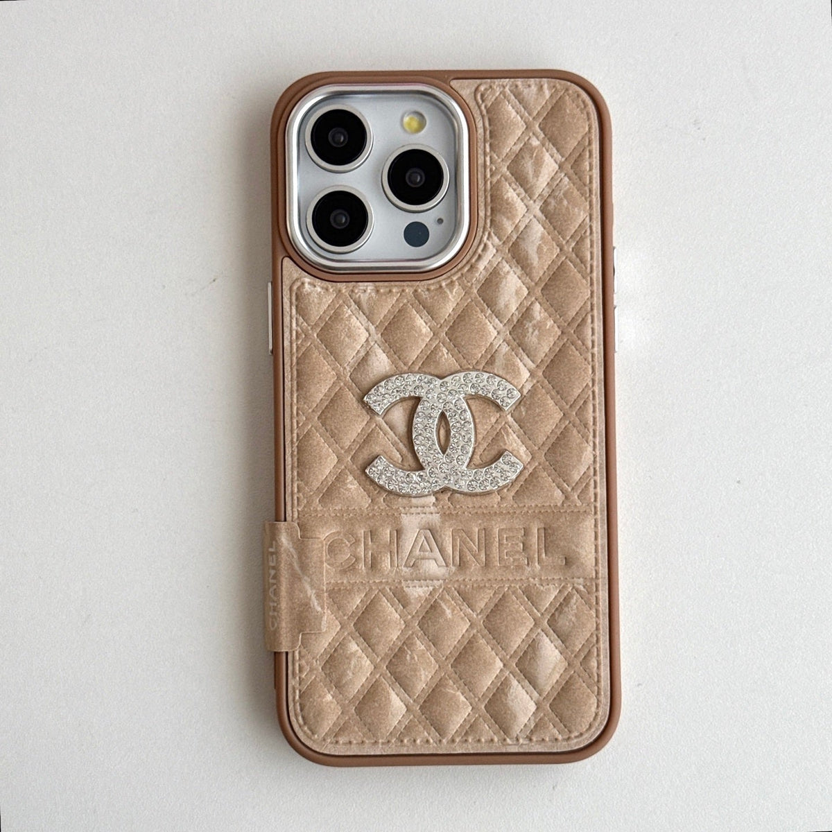Champagne quilted iPhone case with a silver-tone emblem