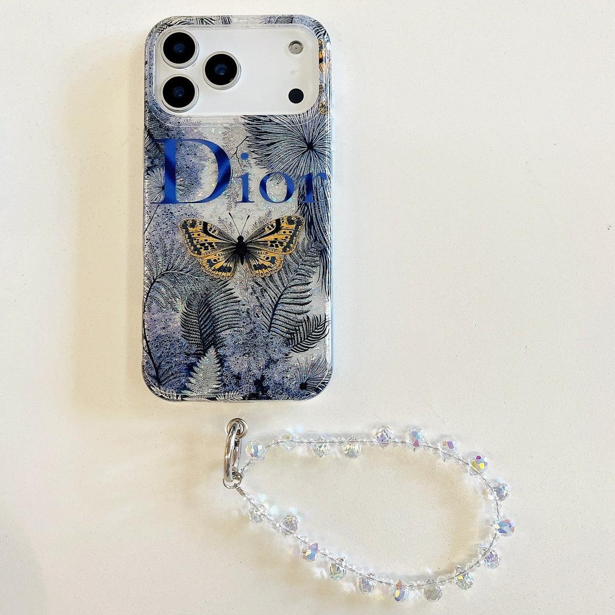 Blue botanical iPhone case with animal-print details and a beaded wrist strap