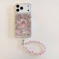 Clear pink floral iPhone case with a perfume graphic and beaded wrist strap