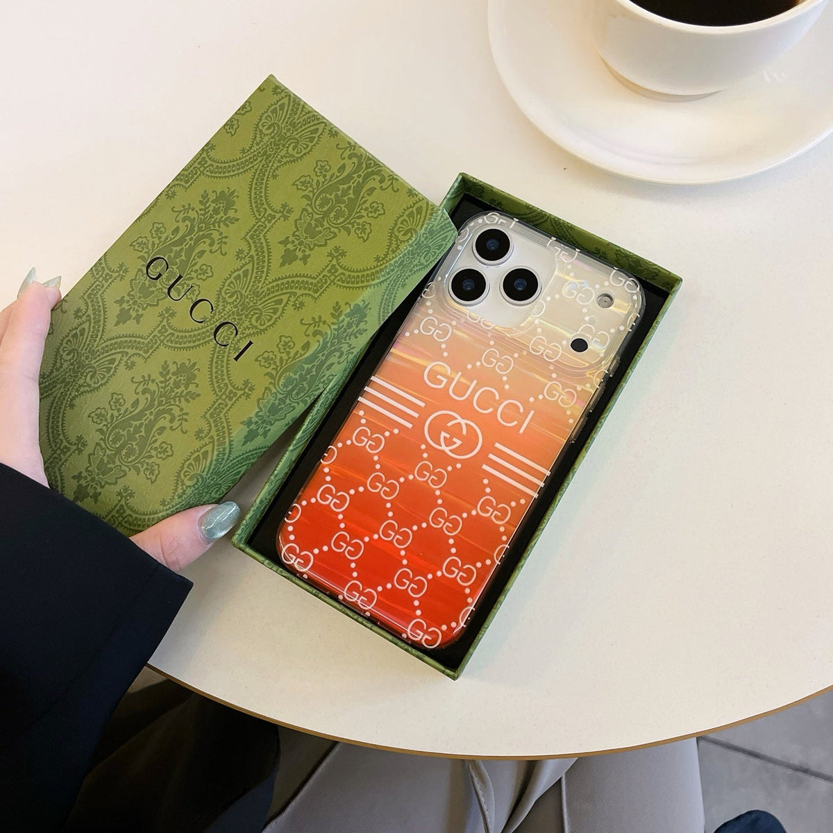 Orange gradient monogram iPhone case shown in a presentation box
