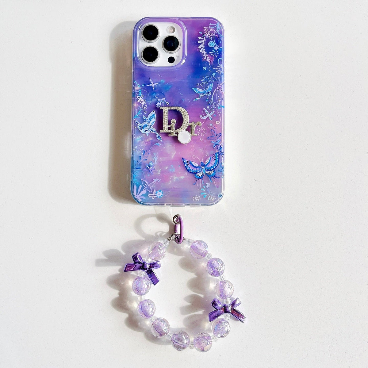Purple and blue marble-effect iPhone case with a butterfly wrist strap