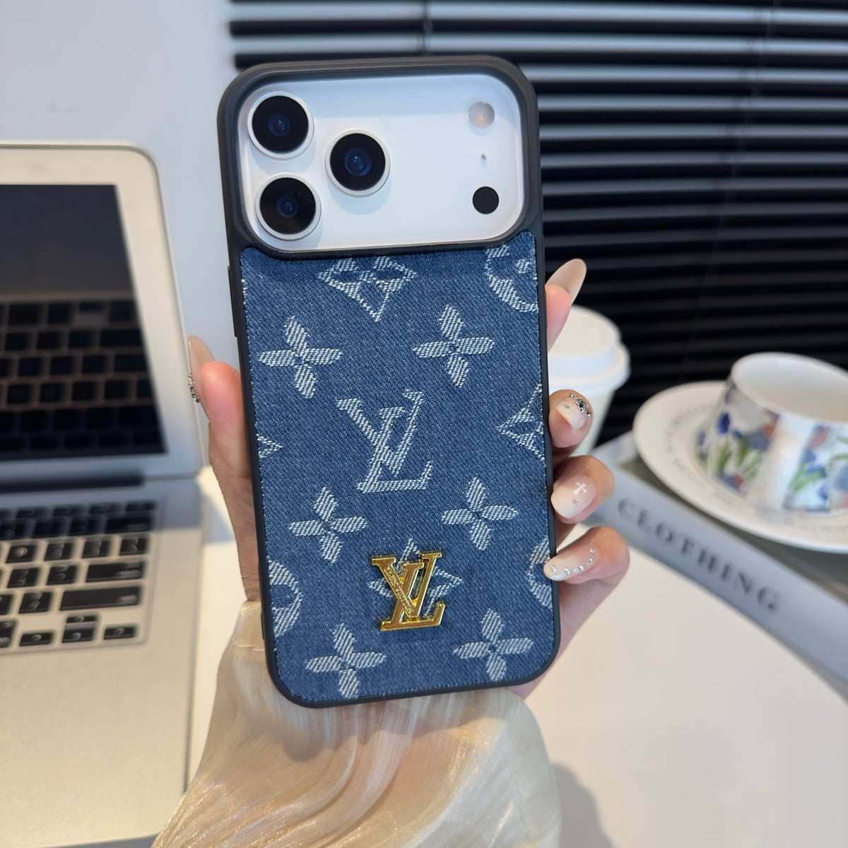 Blue monogram iPhone case with a raised gold-tone center emblem