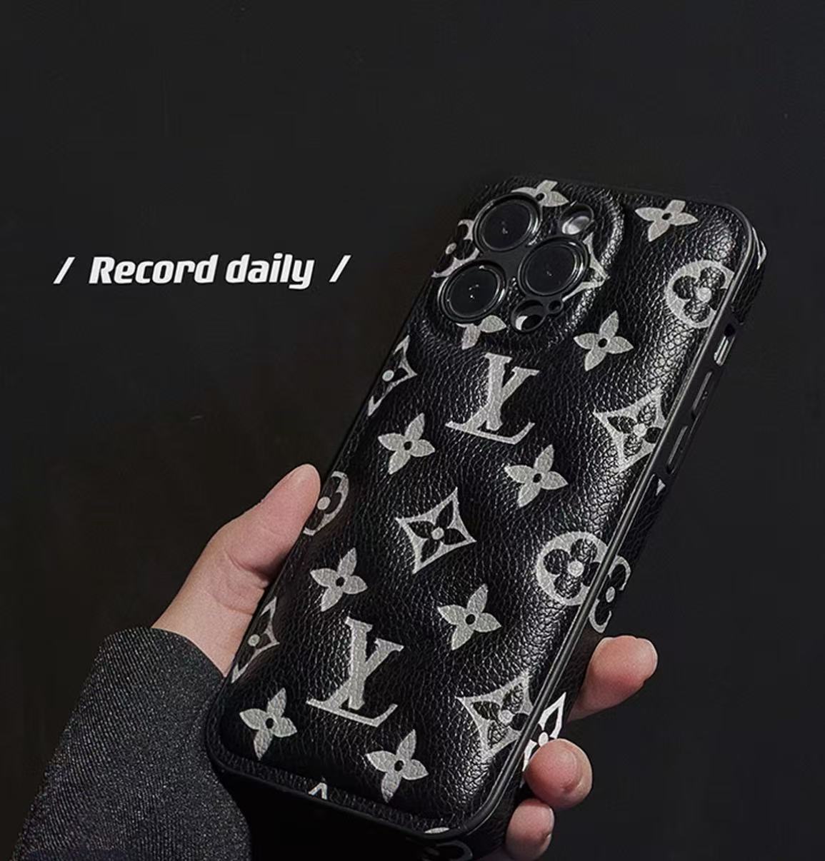 Black and white monogram iPhone case shown in a hand-held product view
