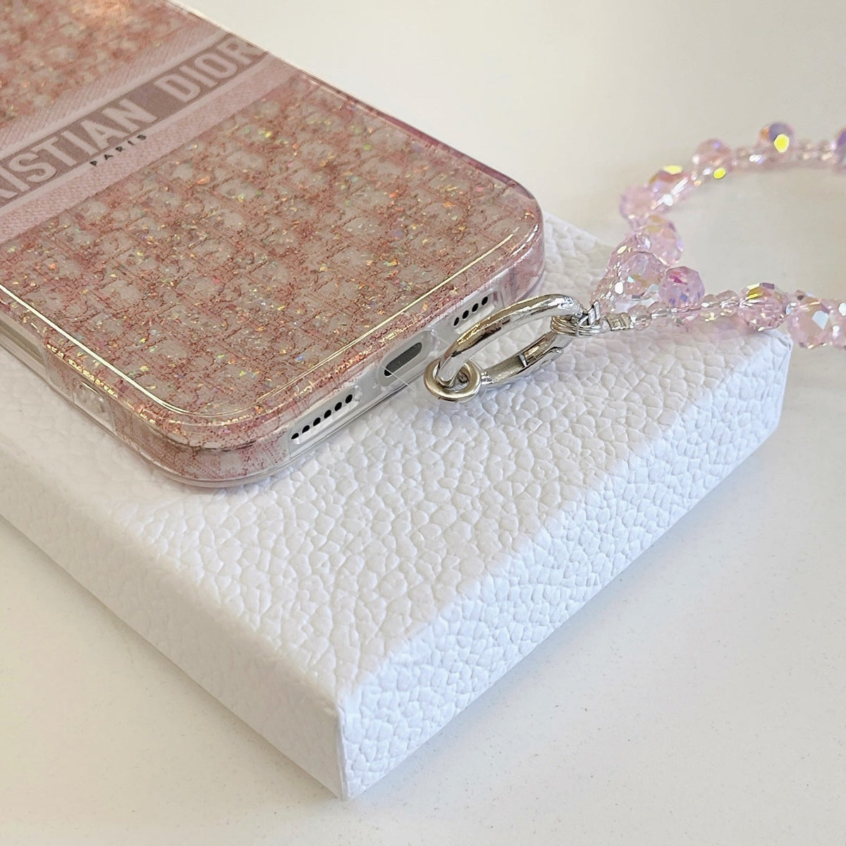 Blush monogram-print iPhone case with a beaded wrist strap shown from another angle