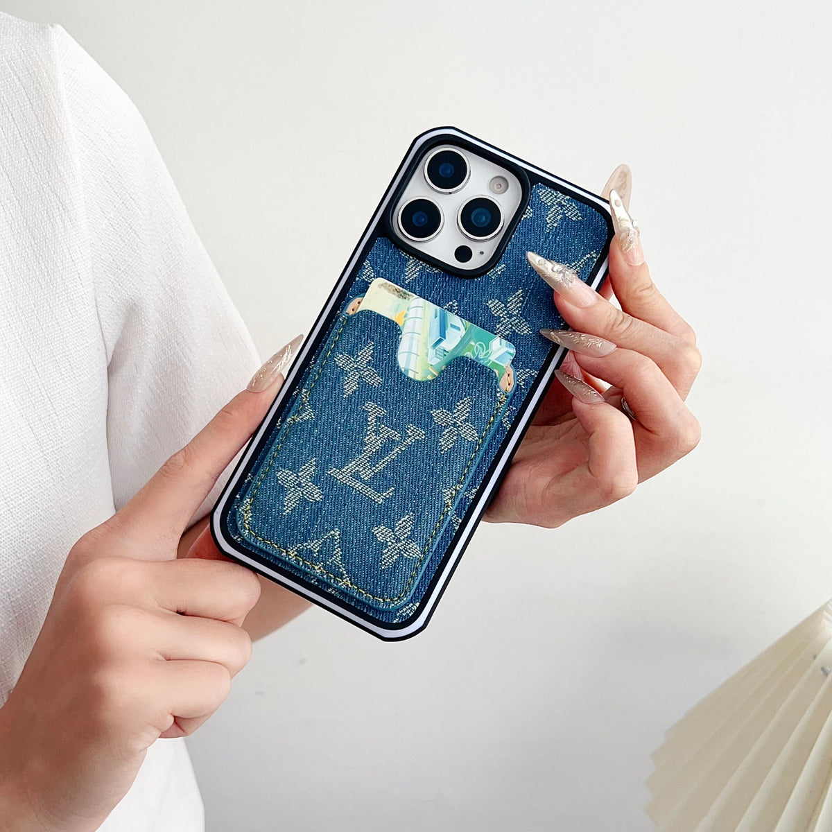 Close-up of the fabric LV iPhone case showing the card slot and textured exterior