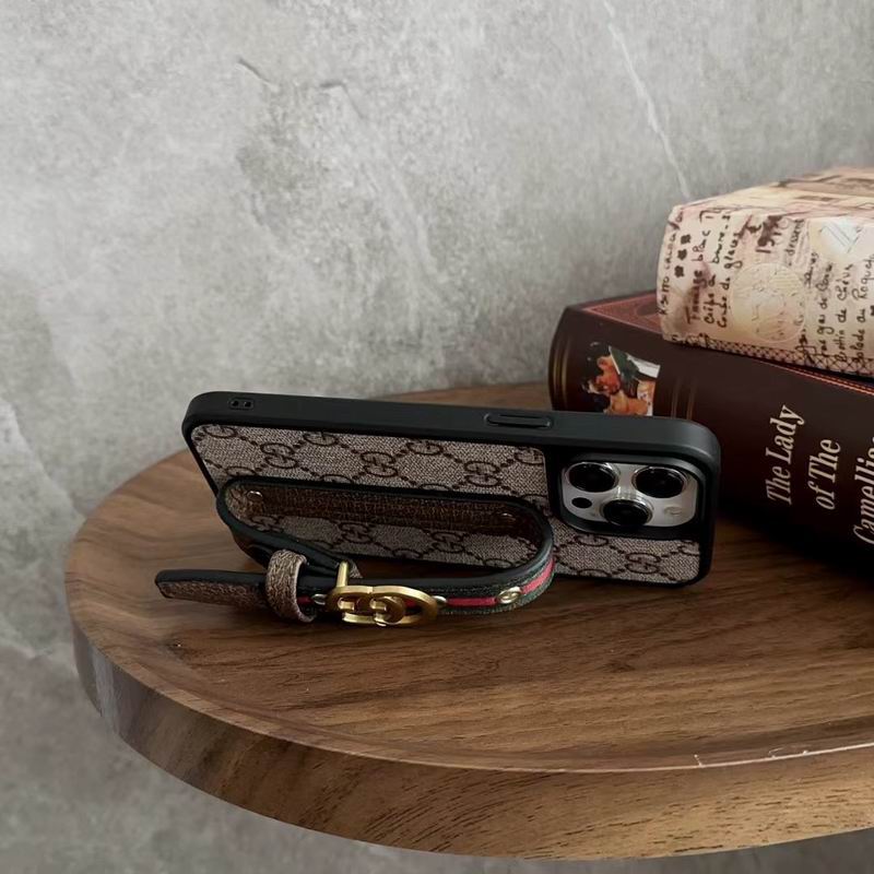 Designer iPhone case showing the adjustable strap used as a kickstand for viewing
