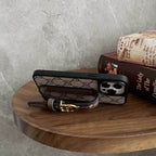 Designer iPhone case showing the adjustable strap used as a kickstand for viewing
