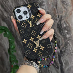 Close-up product view of the black LV golden monogram iPhone case and fitted camera surround