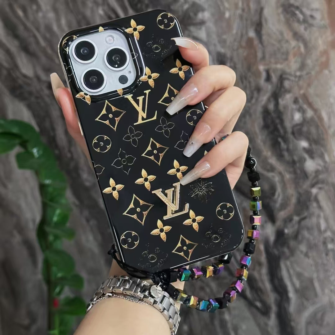 Close-up product view of the black LV golden monogram iPhone case and fitted camera surround