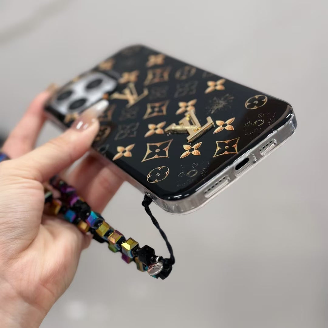 Detailed view of the black LV iPhone case showing the gold-patterned leather back