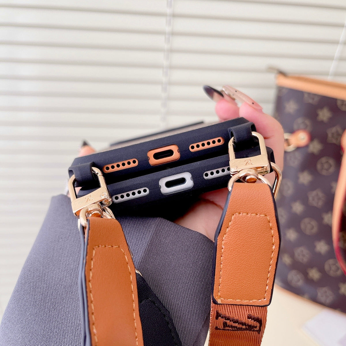 Classic monogram LV crossbody iPhone case showing the protective back cover and strap attachment