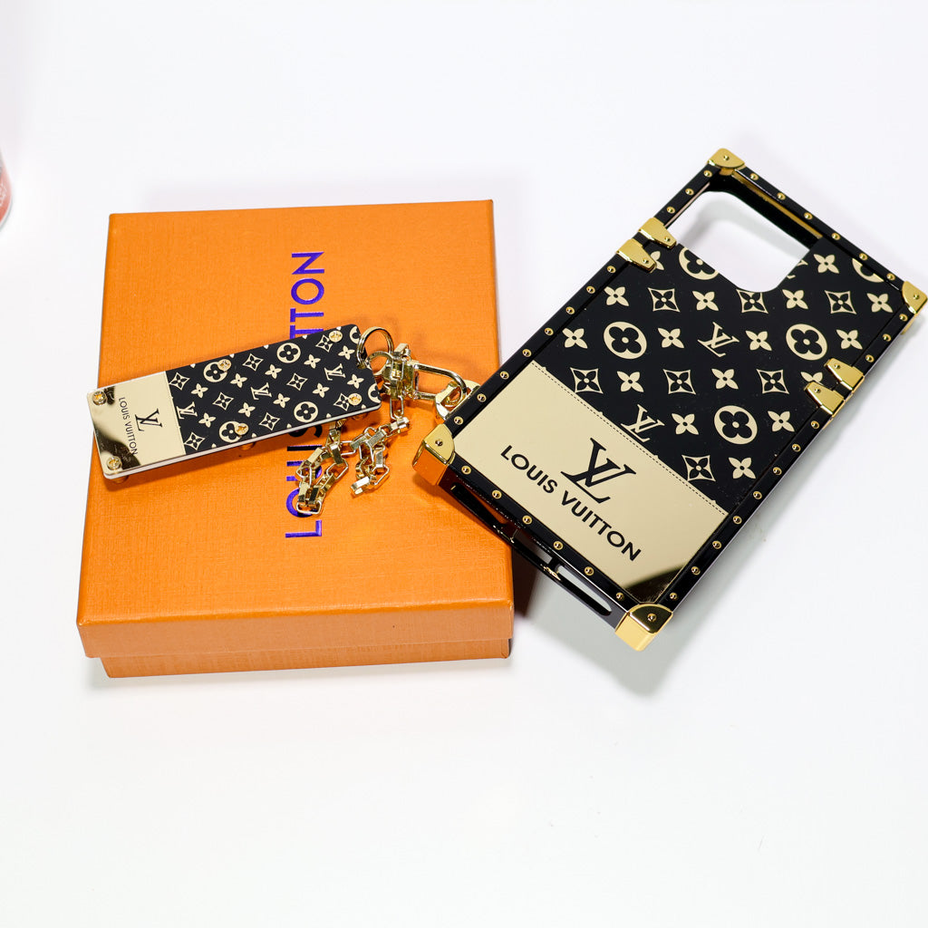 Close-up of the LV Eye Trunk iPhone case showing the golden monogram pattern and hardware