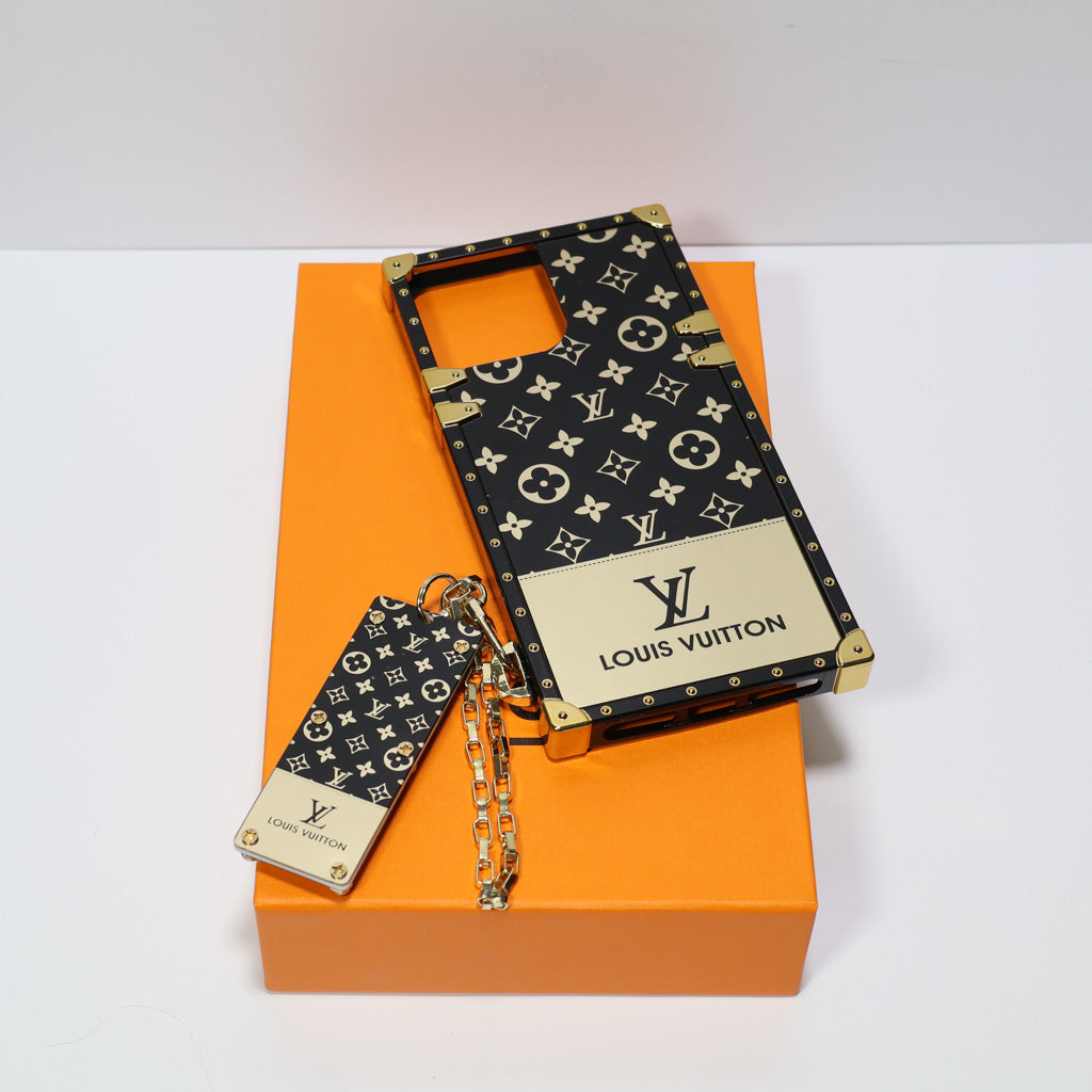 Reverse golden monogram LV Eye Trunk iPhone case showing the glossy trunk-style back
