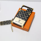 Close-up of the LV Eye Trunk iPhone case showing the glossy pattern and decorative details