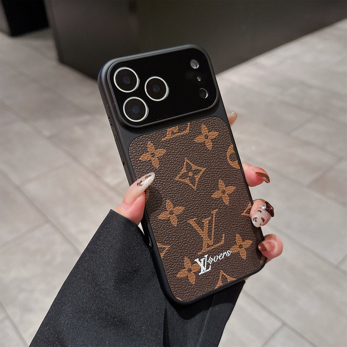 LV lens protection iPhone case close-up showing the raised lens frame and leather texture