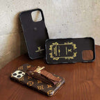 Close-up of the designer iPhone case showing the hand strap and patterned back finish