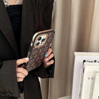 Close-up of the LV monogram iPhone case highlighting the gold-tone edges and finish