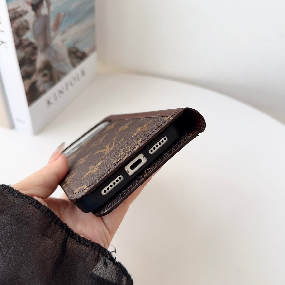 Louis V folio wallet iPhone case close-up showing the camera opening and finished edges