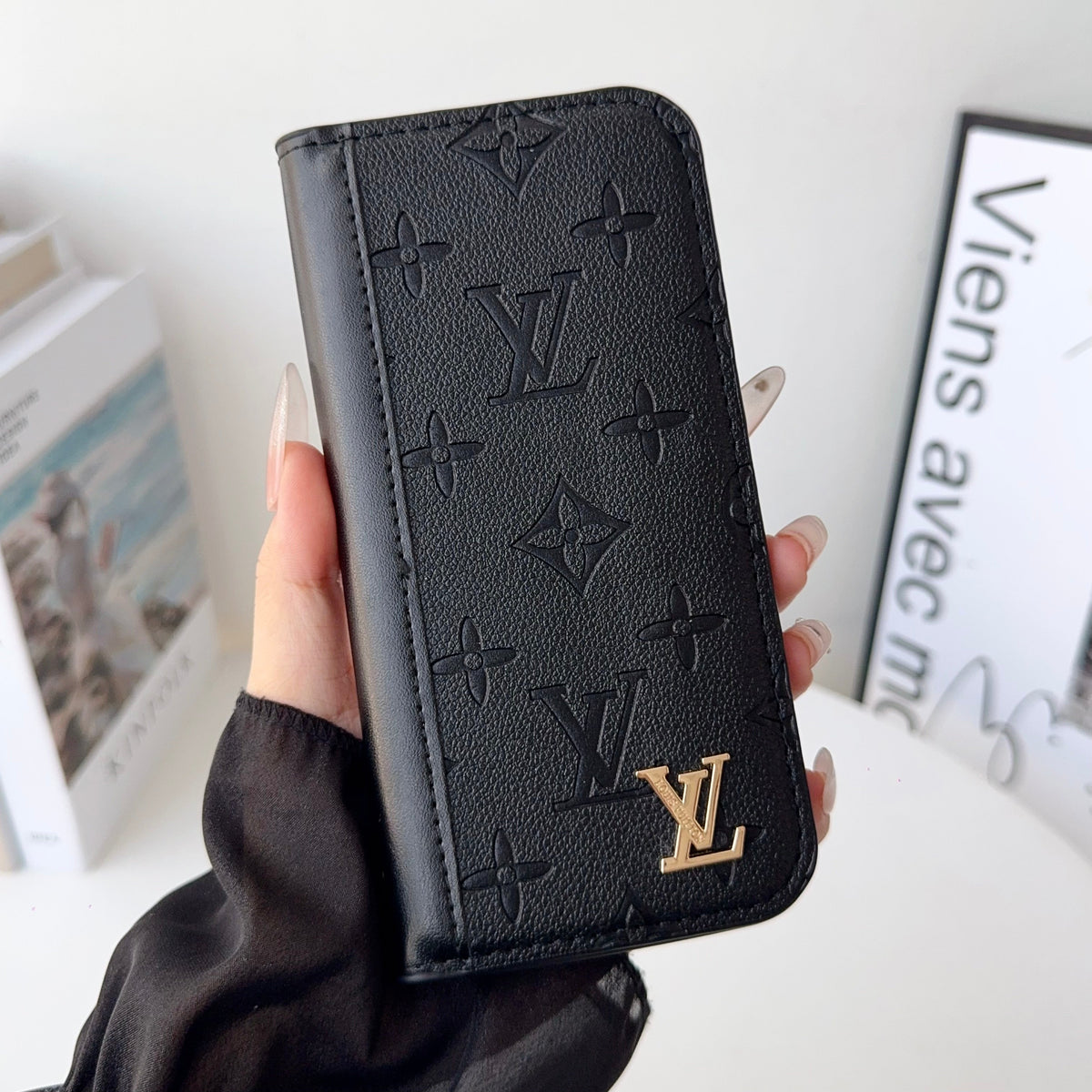 Louis V folio wallet iPhone case close-up showing the folding cover and leather finish