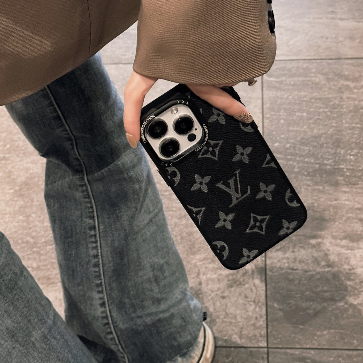Black monogram classic leather iPhone case showing the dark patterned back design