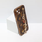 Close-up of the ornament iPhone case showing the hand strap, leather finish and card storage