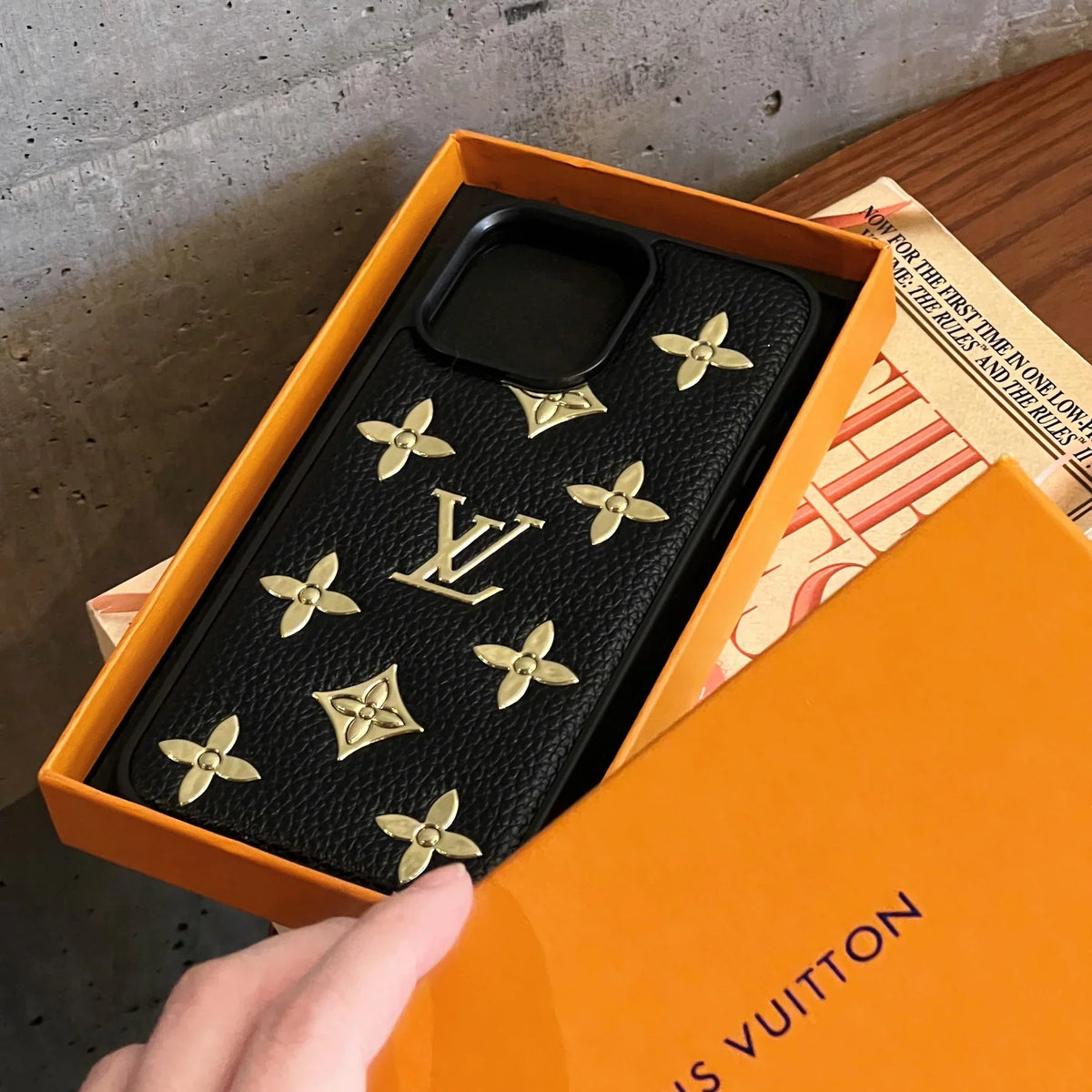 Detailed view of the luxury golden monogram iPhone case showing leather texture and gold accents