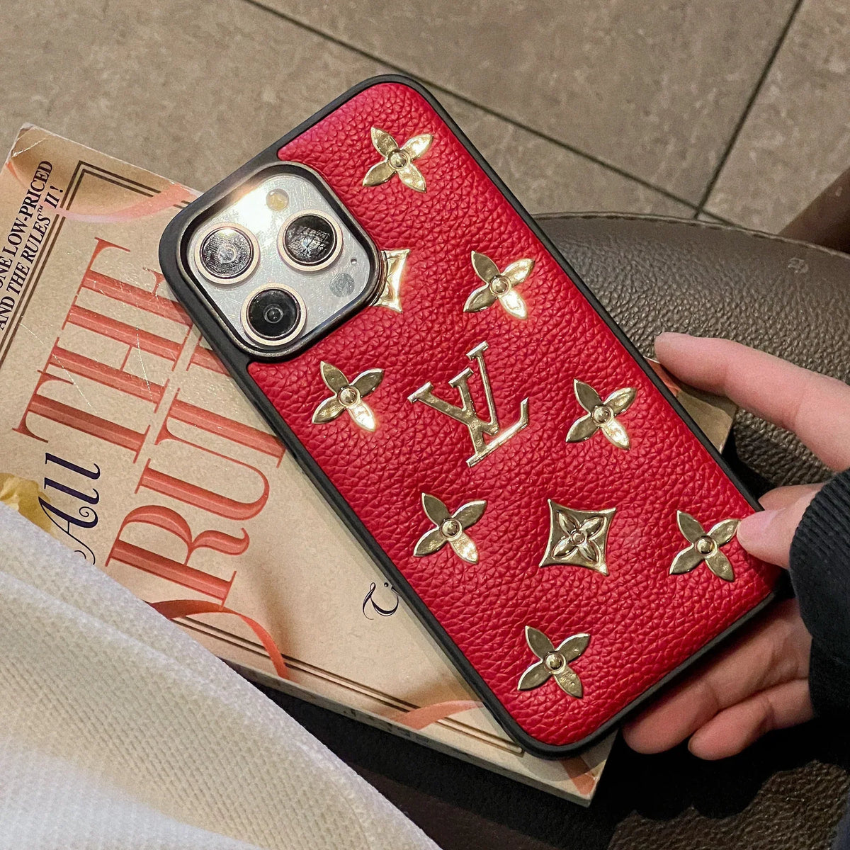 Golden monogram leather iPhone case showing the rear pattern, camera area and protective corners