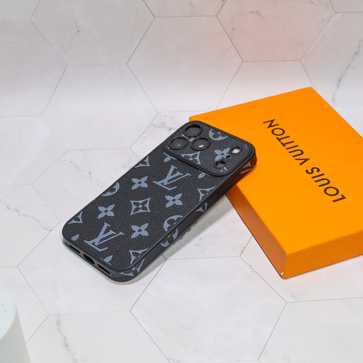 LV iPhone case with swappable camera lens frame close-up showing the camera frame and back pattern