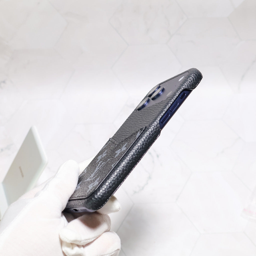 Detailed view of the LV black monogram iPhone case showing the dark leather finish