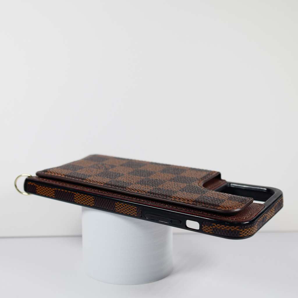 Checkered leather crossbody iPhone case close-up showing the strap attachment and material finish