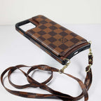 Checkered leather crossbody iPhone case showing the slim phone fit and carrying strap
