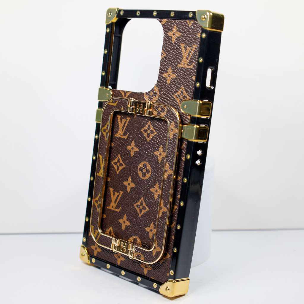 Close-up of the luxury trunk iPhone case highlighting the metal hardware and leather finish