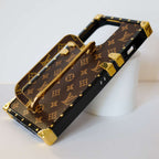 Detailed view of the luxury trunk iPhone case showing the foldable stand and structured frame