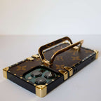 Louis Vuitton trunk iPhone case showing the leather-patterned back and fitted protective corners