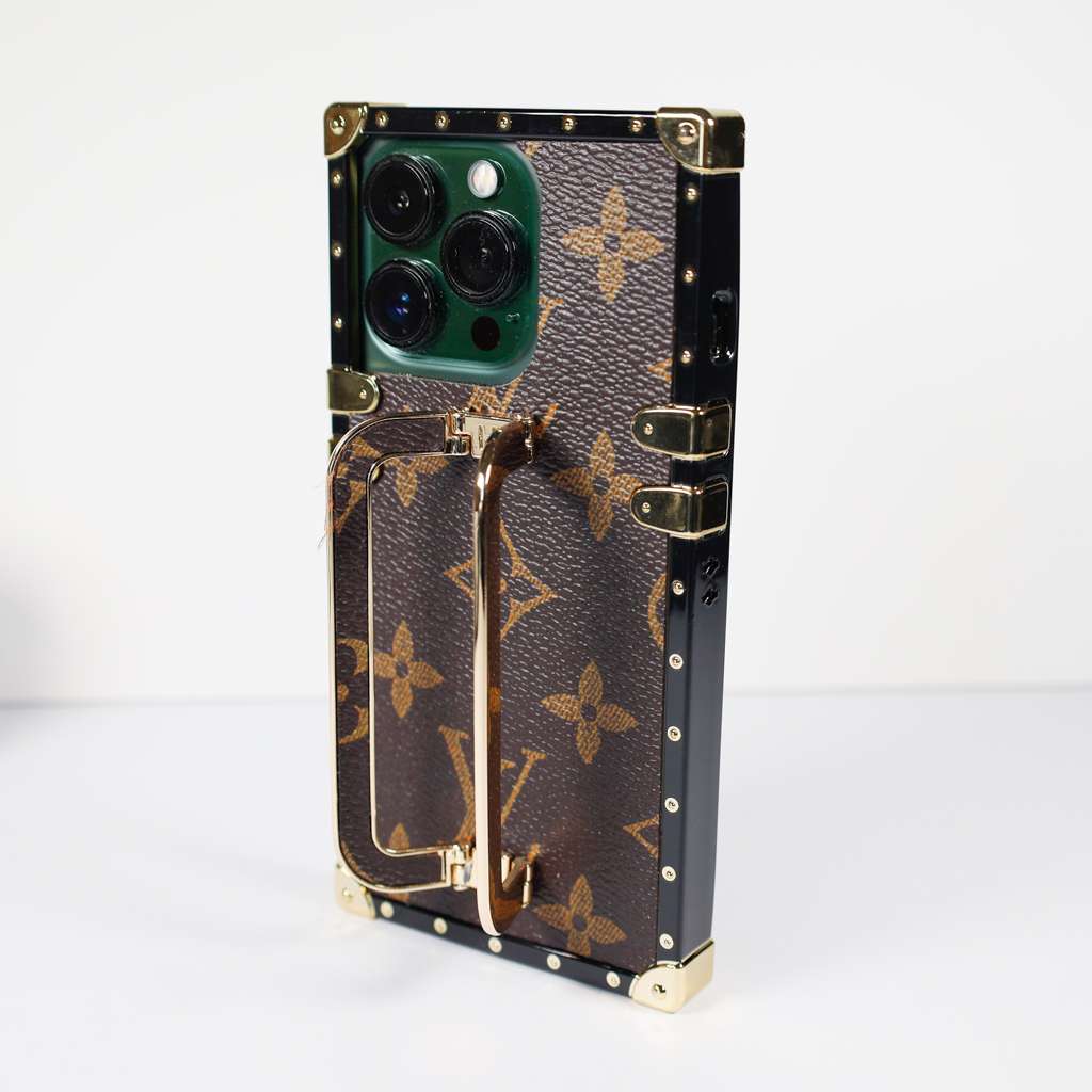 Louis Vuitton trunk iPhone case close-up highlighting the hardware and leather texture