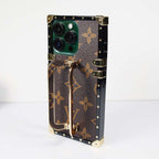 Louis Vuitton trunk iPhone case close-up highlighting the hardware and leather texture