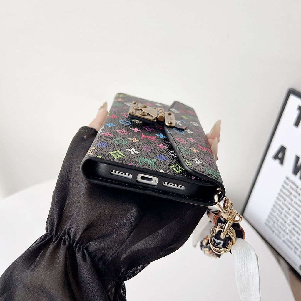 Crossbody wallet iPhone case showing the colorful patterned back and carrying strap