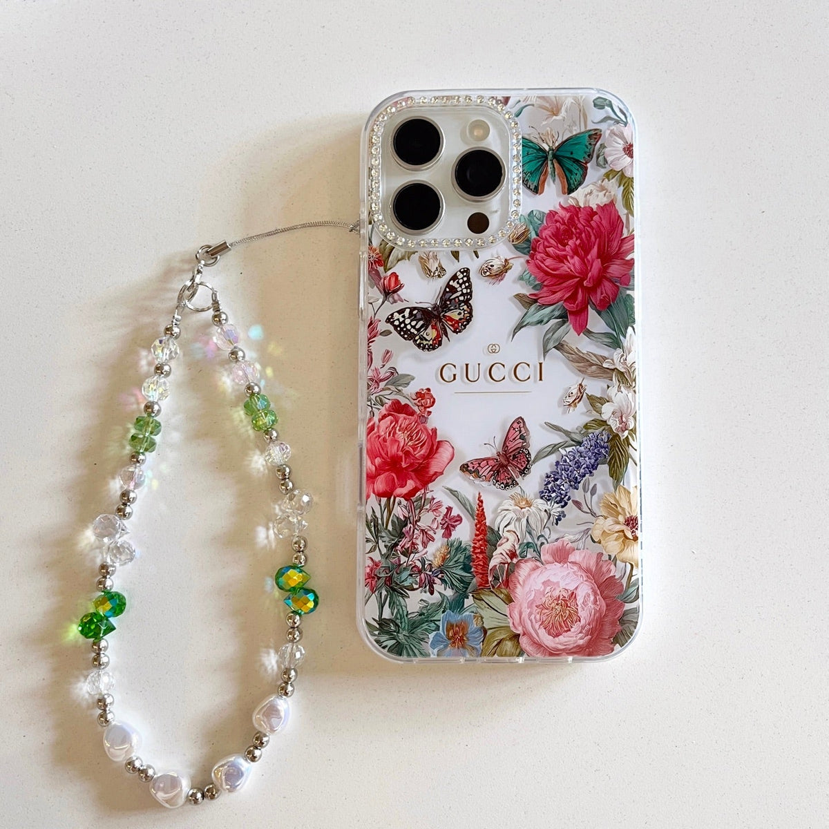 Floral iPhone case with roses, butterflies, and a beaded wrist strap