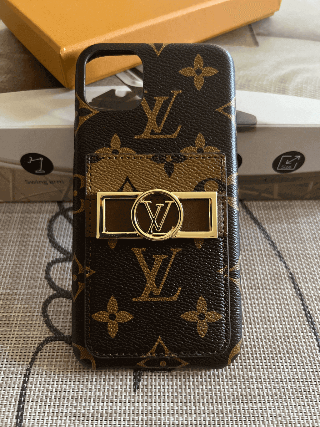 Monogram iPhone case shown from the back with protective corners and leather texture