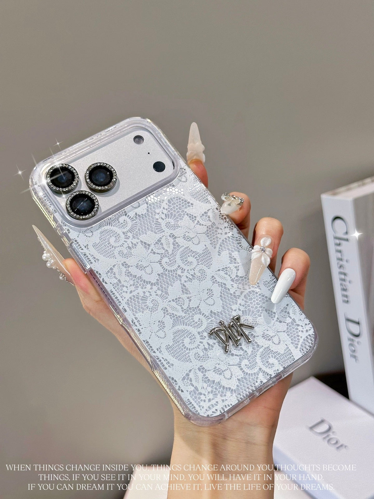 White and silver lace-pattern iPhone case with a small central emblem