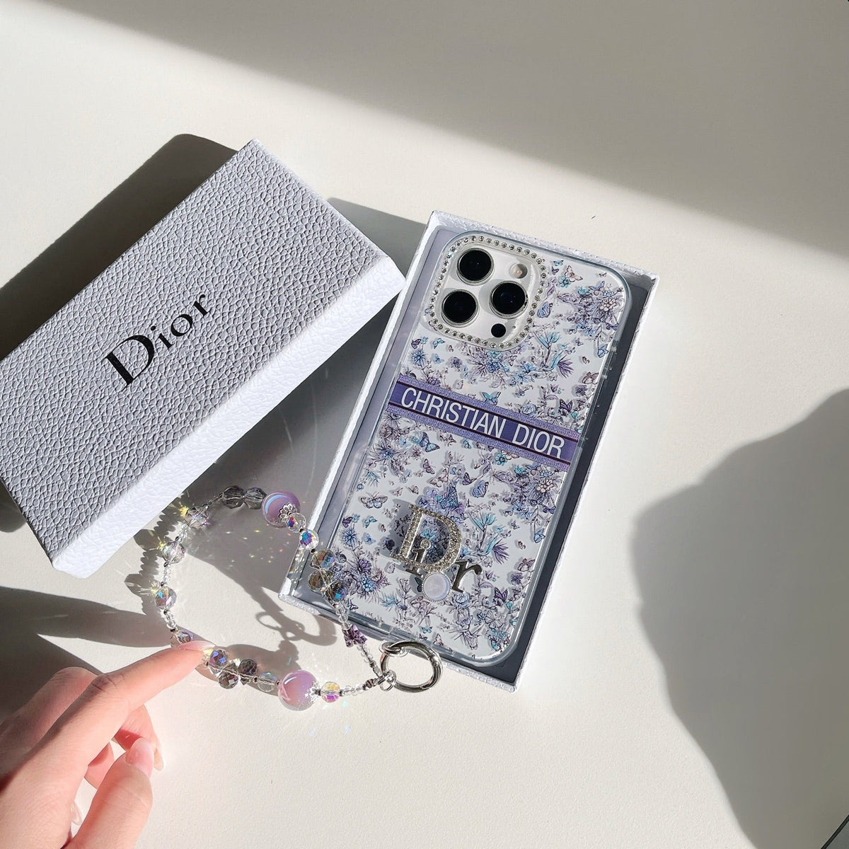 Blue and white monogram iPhone case with a jeweled frame and charm