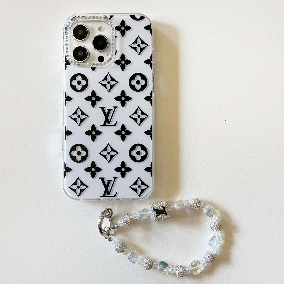 White and black high-contrast monogram iPhone case with a beaded wrist strap