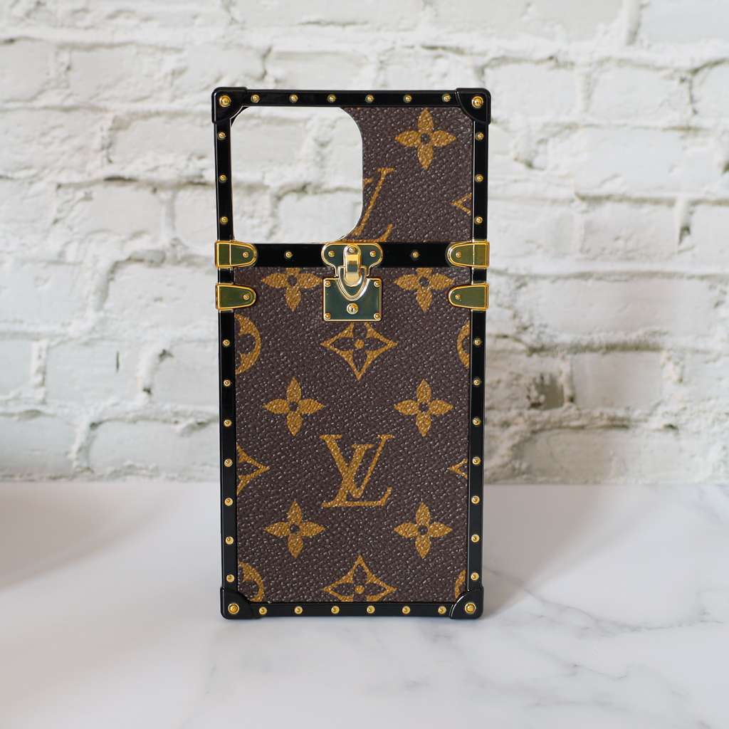 Reverse monogram Eye Trunk iPhone case front view showing the structured trunk-style design