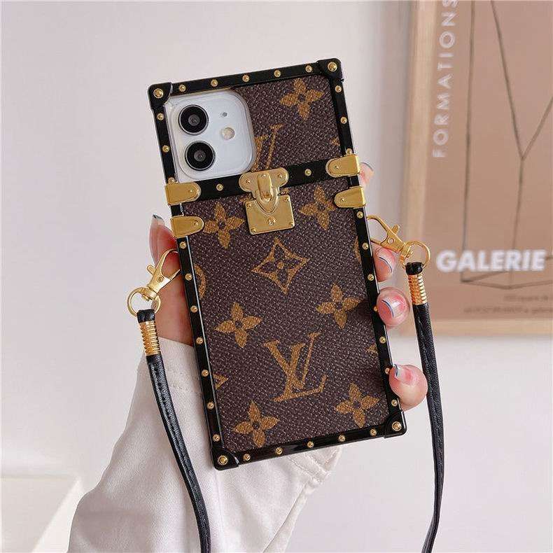 Brown monogram LV trunk iPhone case showing the patterned rear cover and camera opening