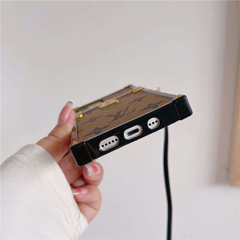 LV trunk iPhone case showing clear charging port access and protective lower edge